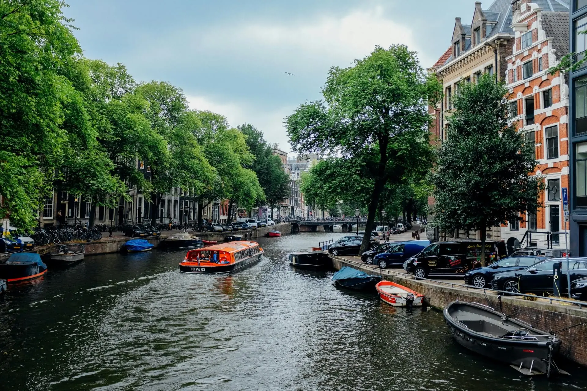 Amsterdam canal houses with traditional Dutch architecture along a tree-lined waterway